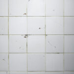 old and damaged looking white square tiles.