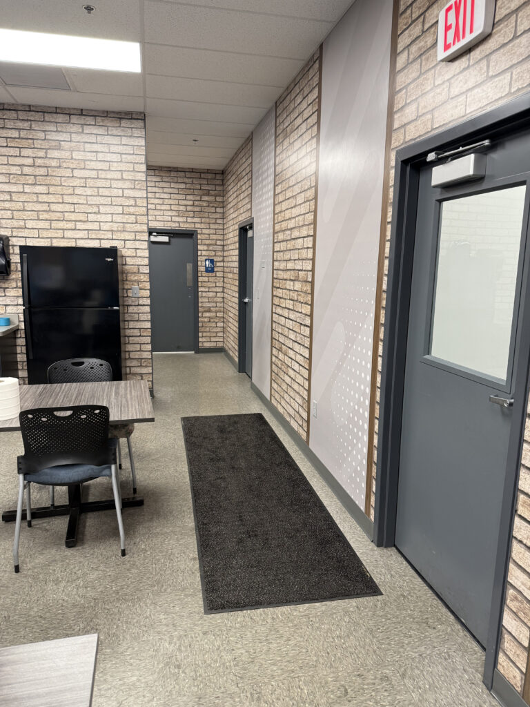 entrance into an employee breakroom with Artizan printed panels on the wall in brick and dots